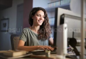 Une femme sereine et organisée qui travaille sur son ordinateur de bureau à la maison.