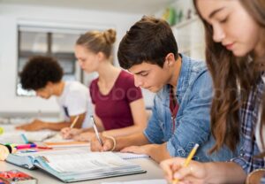 Groupe de lycéens concentrés qui prennent des notes en classe à la rentrée au lycée