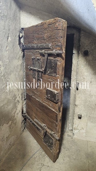 Ancienne porte en bois du cachot de la tour de l'horloge de Vauvert, avec ses gros verrous en fer